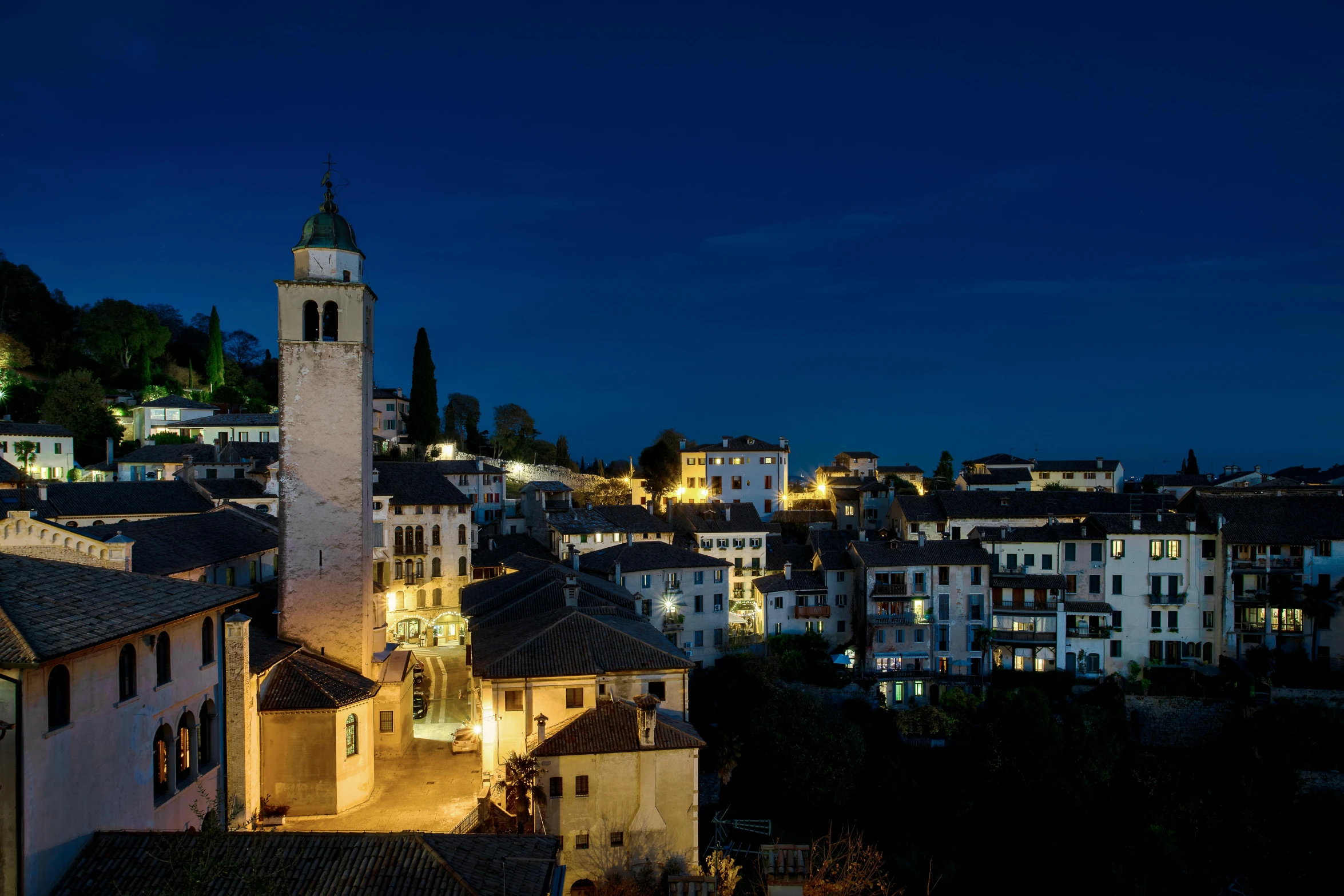 a view of some buildings and a church at night