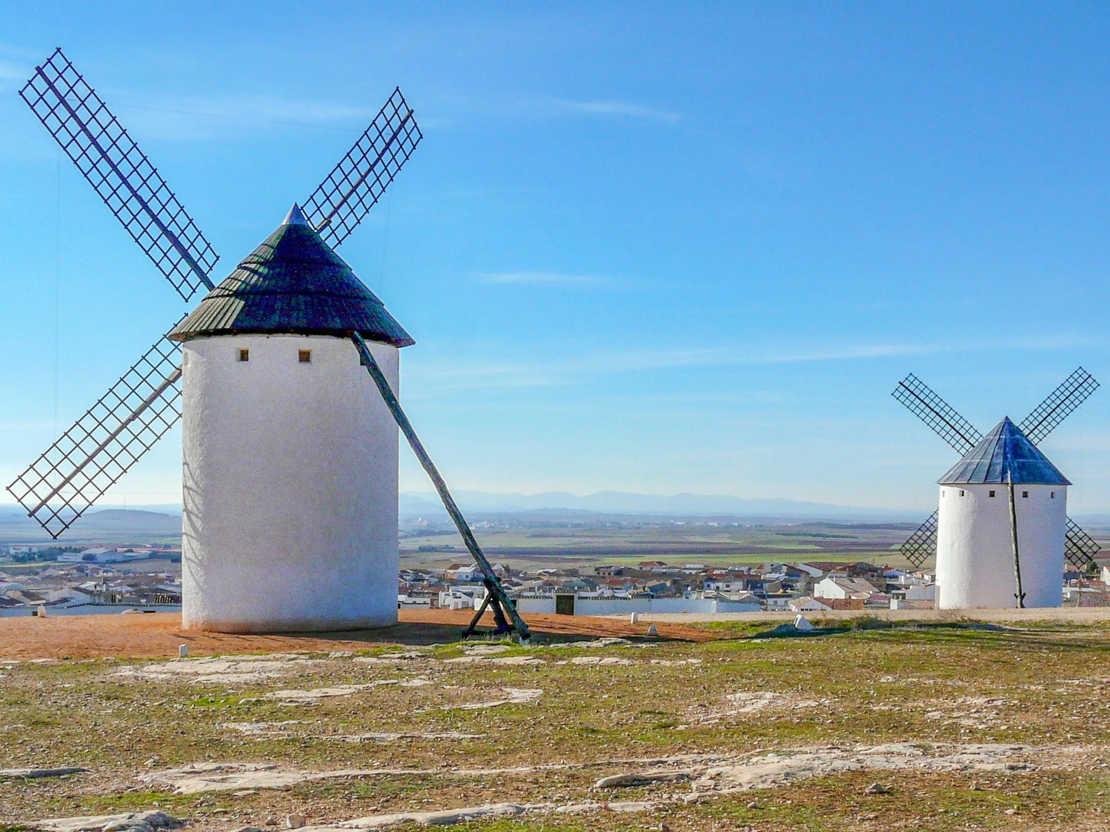 four white windmills with hills in the background