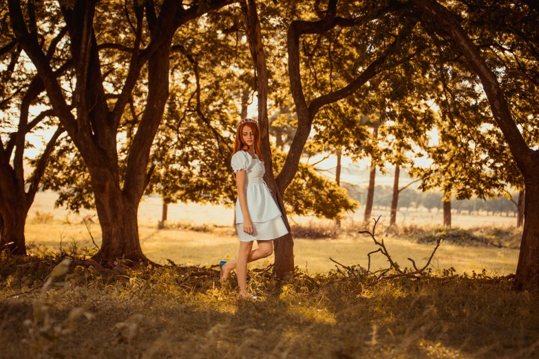 a girl standing in front of several trees