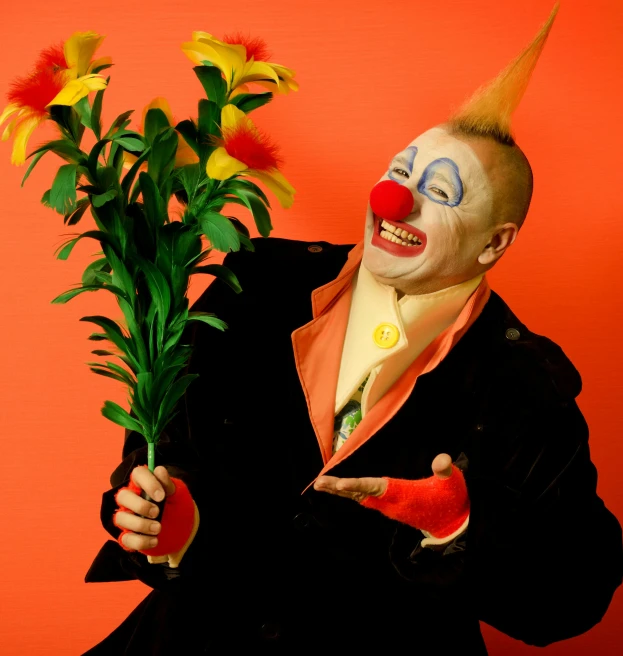 the clown is holding a bunch of flowers