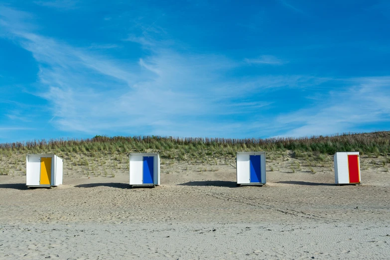 there are four colorful box on the sand