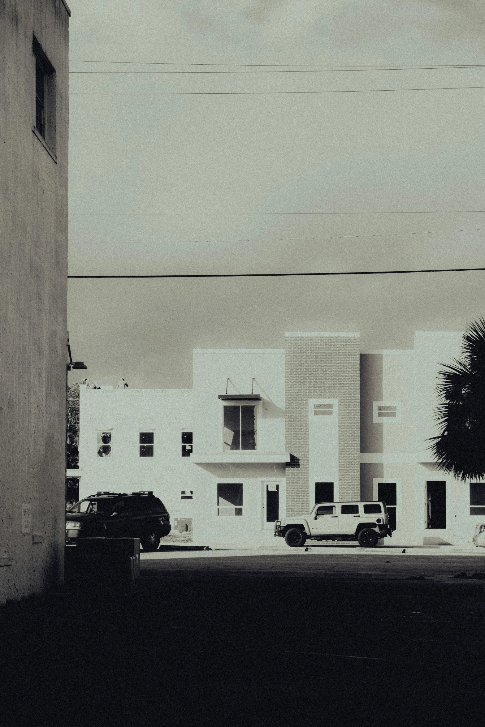 a view looking down an alley way with some buildings on one side and cars parked on the other