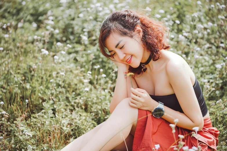 woman sitting down in grass smiling at camera