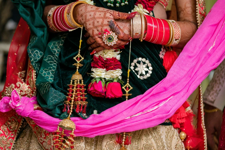 a couple dressed in green and pink wear indian jewelry