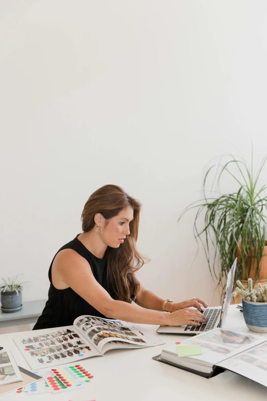 a woman working on a laptop at a table