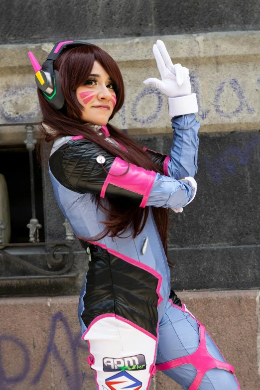 the girl in pink and gray costume poses with her fingers up