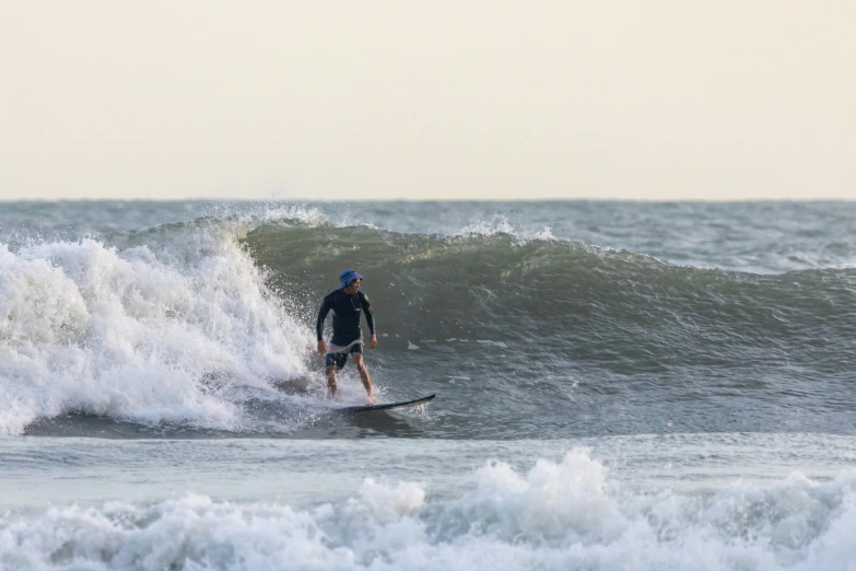 a man riding a wave on top of a surfboard