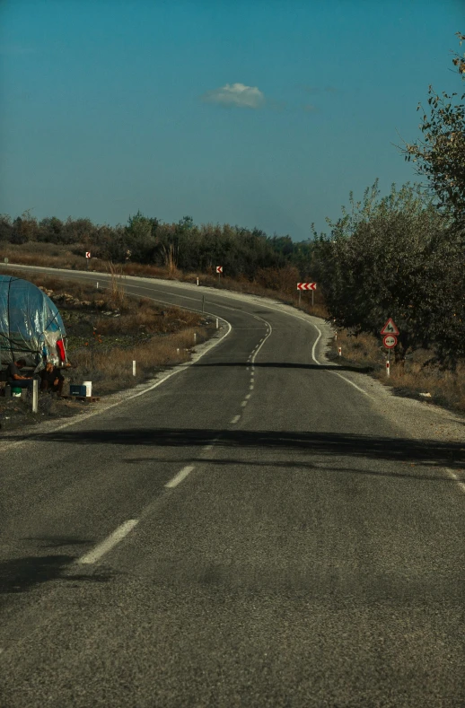 an empty road has a very large tanker trailer on it