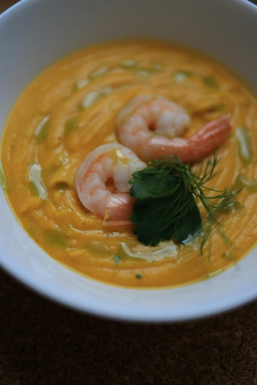 a bowl of soup with shrimp and broccoli