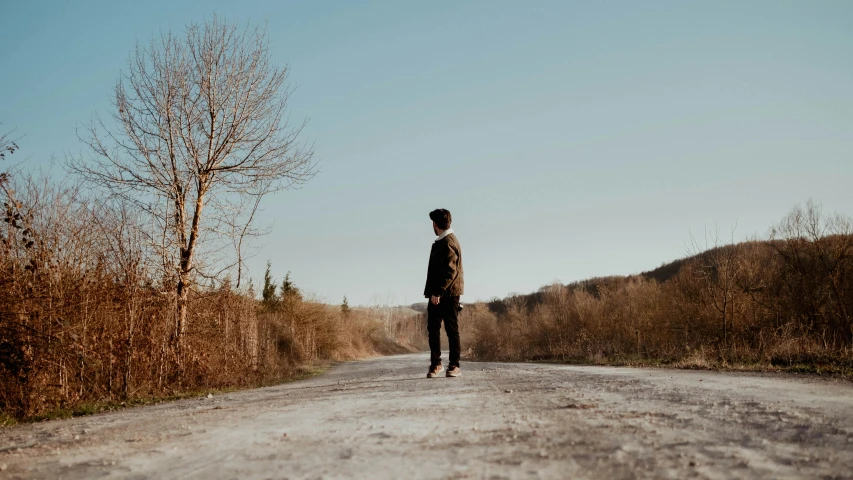 the man is walking down the dirt road