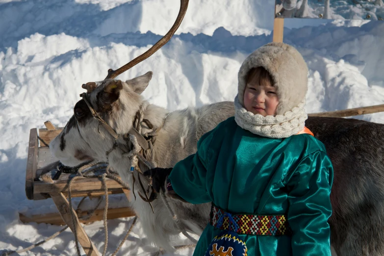 a  in green standing next to an animal