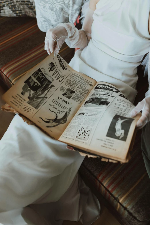 woman in victorian costume reading the newspaper with white gloves