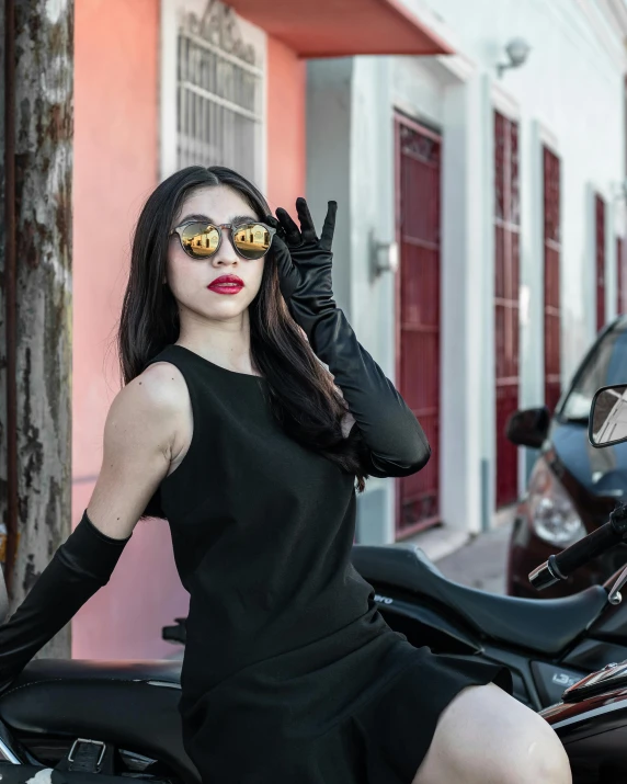 a woman on a motorcycle in black dress with sun glasses