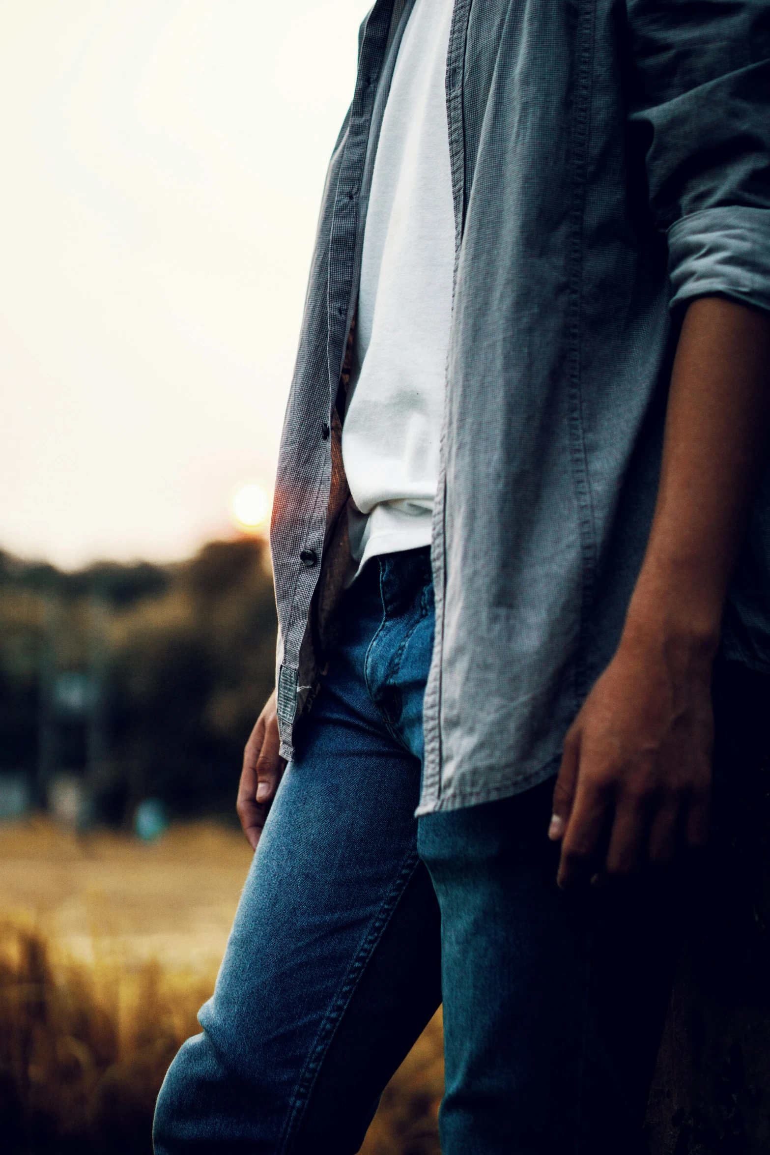 a man with glasses wearing blue jeans and a gray jacket