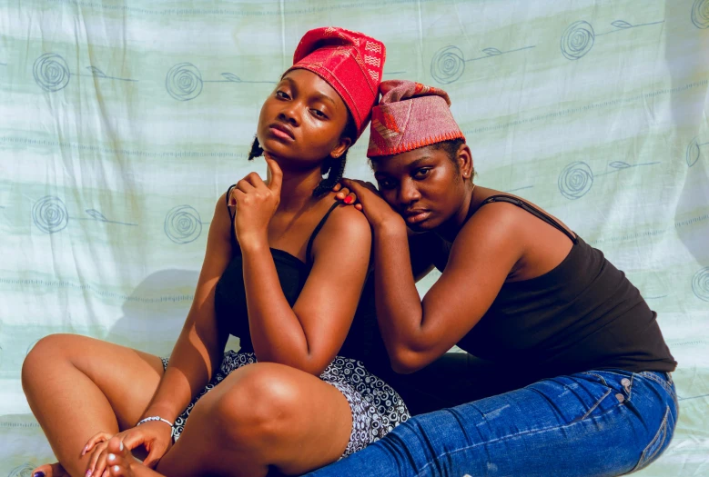 two females are sitting together on the ground