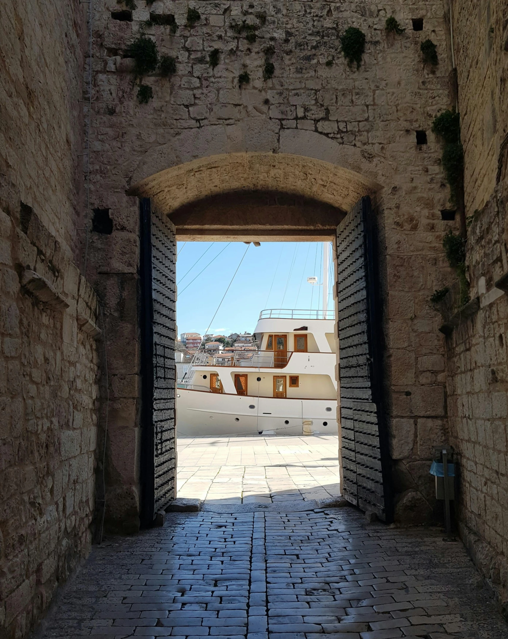 an open archway between two brick buildings with power lines in the distance