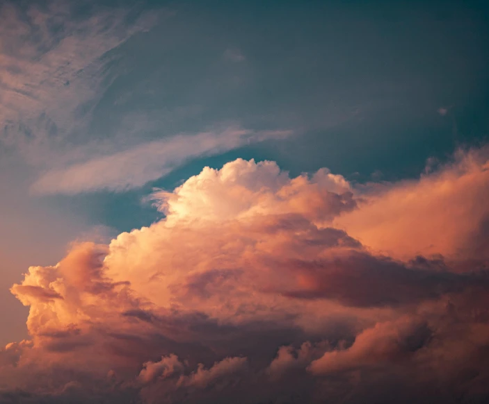 a plane flying through the cloudy sky in the sun