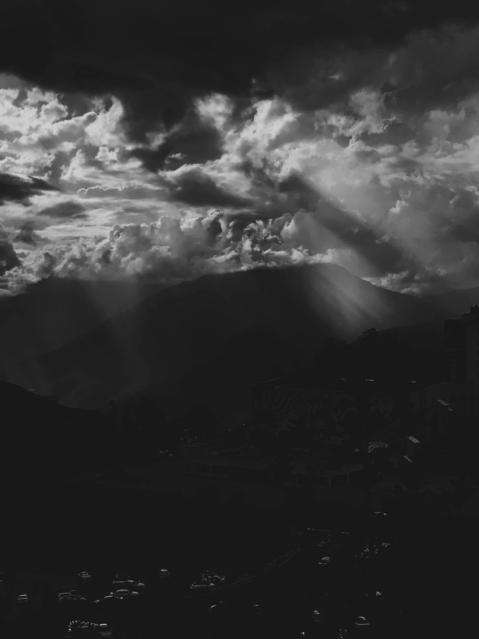 dark clouds cover the skyline as a full moon hovers in the sky