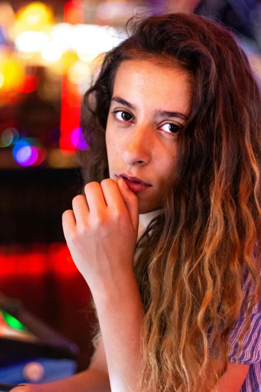 a woman sits in a casino with her hands resting her chin