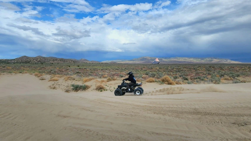 a man riding an atv through the desert