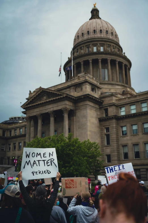 some protesters outside a large building with signs