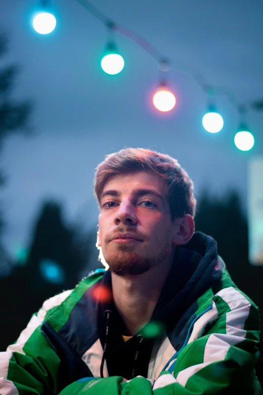 man with white and green jacket in front of colorful light