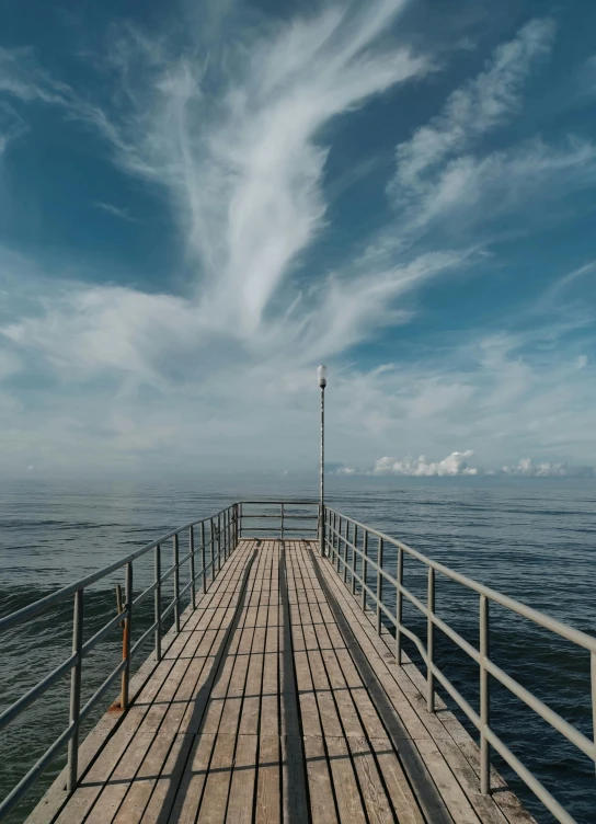 a boardwalk with water on either side leading into the ocean