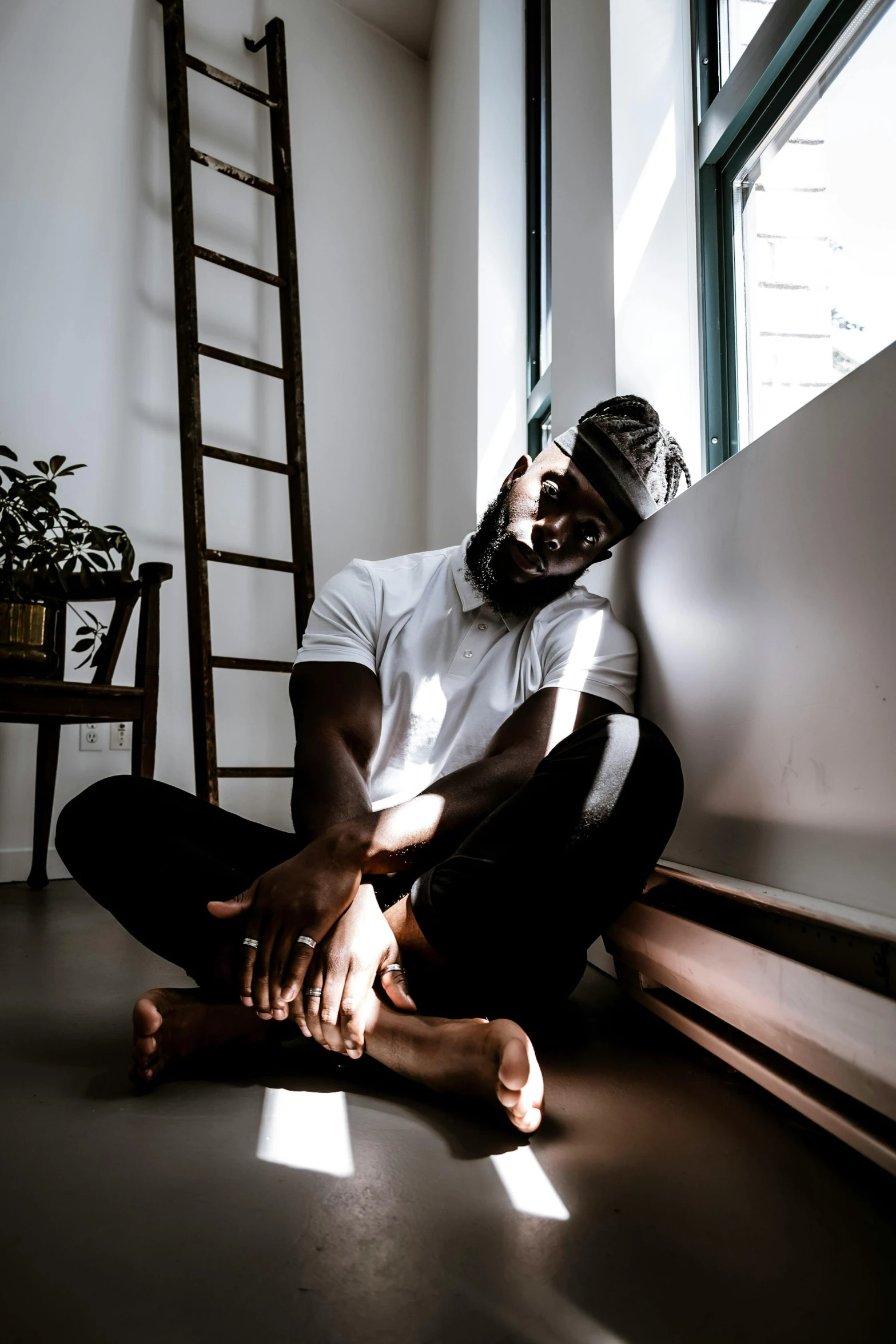 a man sitting on the floor by a window