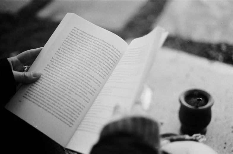 a person sitting with their feet on the table reading a book