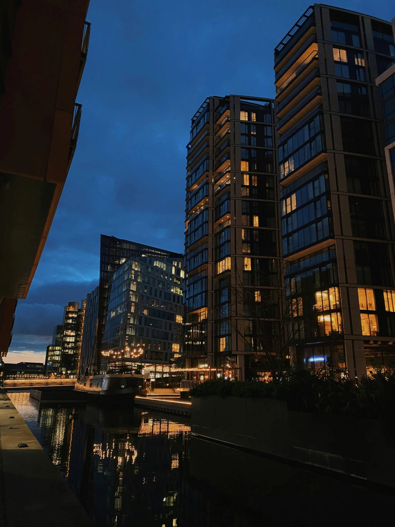 a cityscape with skyscrs at night reflected in water