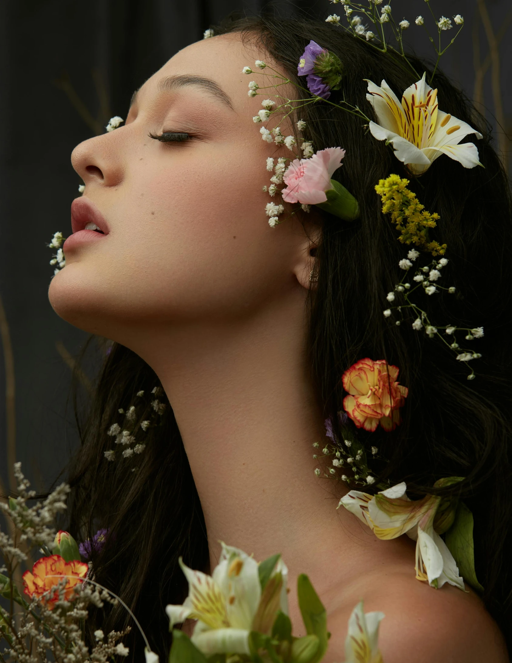 a beautiful woman has long black hair with flowers on her head