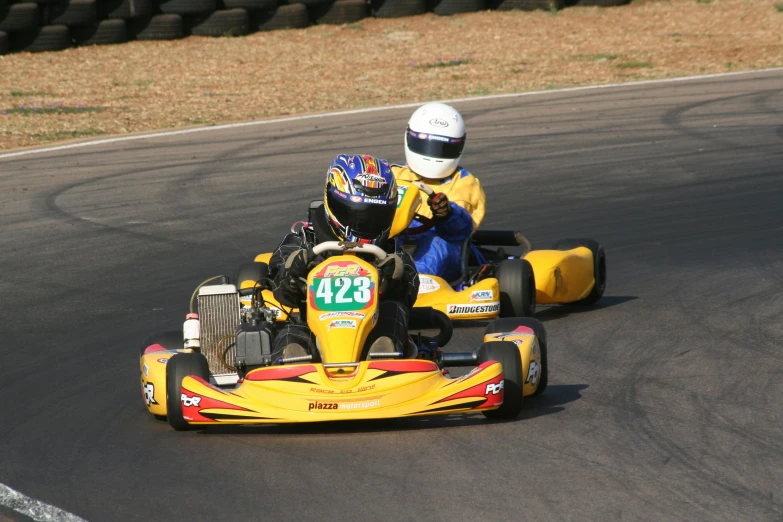 two young people racing kart race on a track