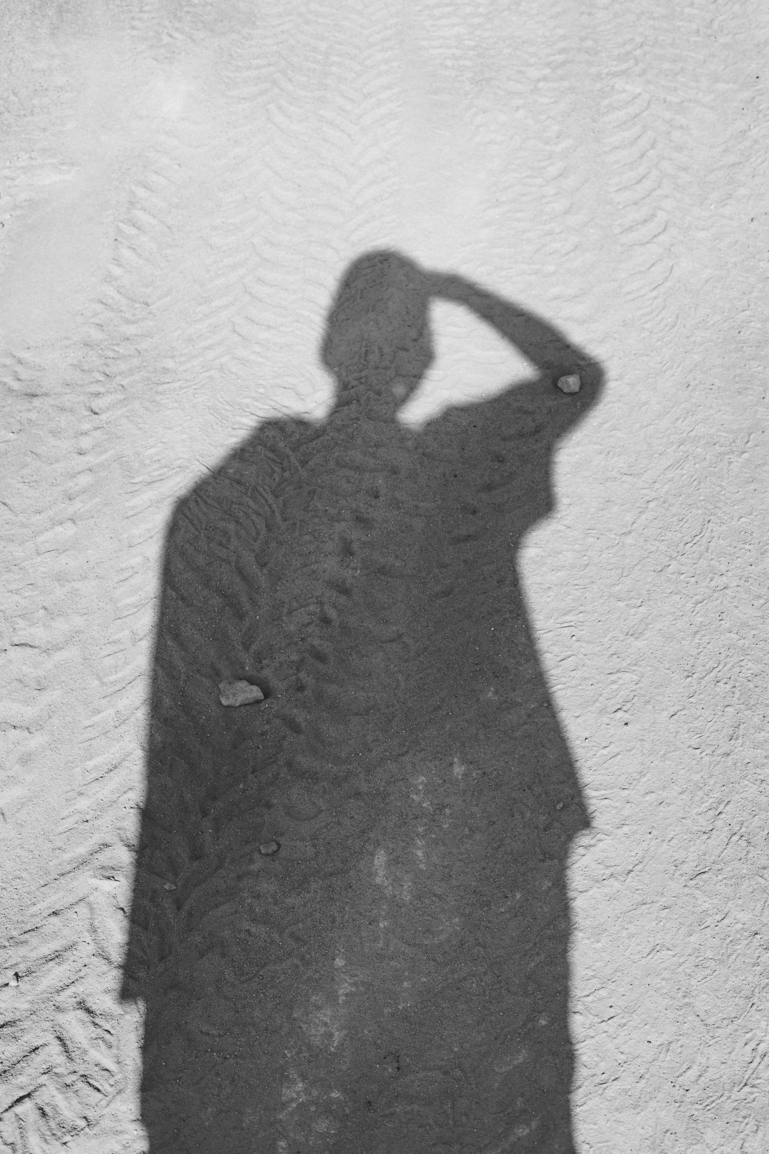 a man with a hat on taking a po in the sand