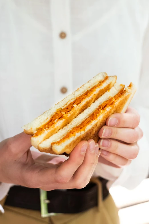 a man holding onto a grilled  dog