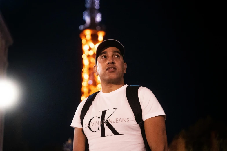 man looking up at the tower in the night