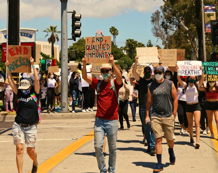 people walking down the street while wearing masks