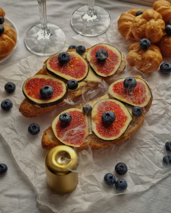 there are pastries that include figurines, blueberries and a few more on the table