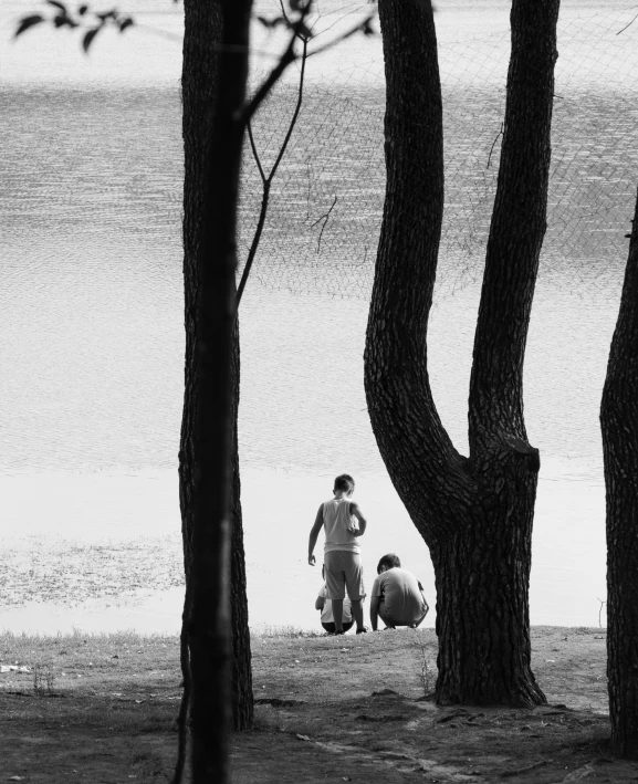 people walking on a beach next to trees