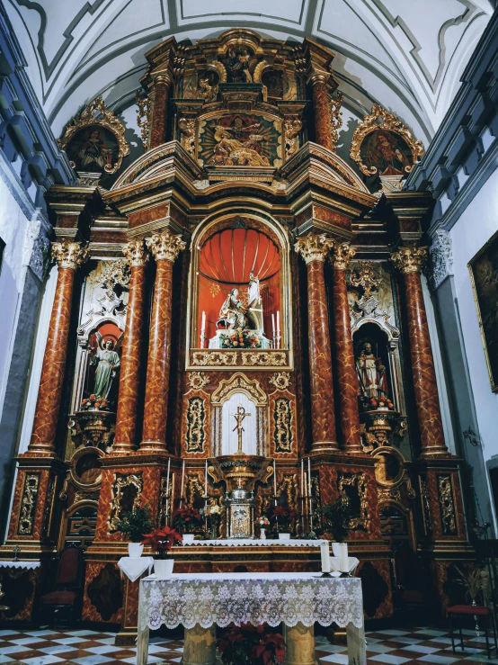 a golden alter in an old church with an elaborate painted ceiling