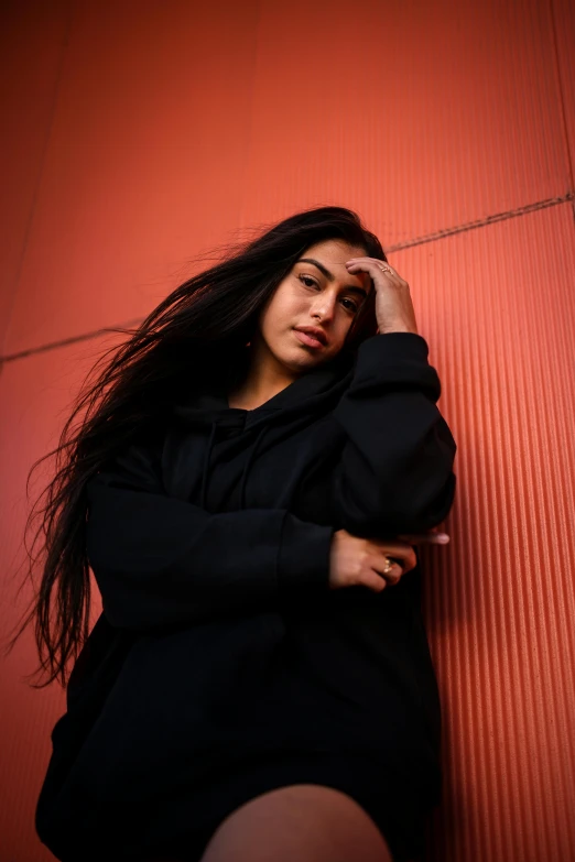 the woman is posed on the red wall