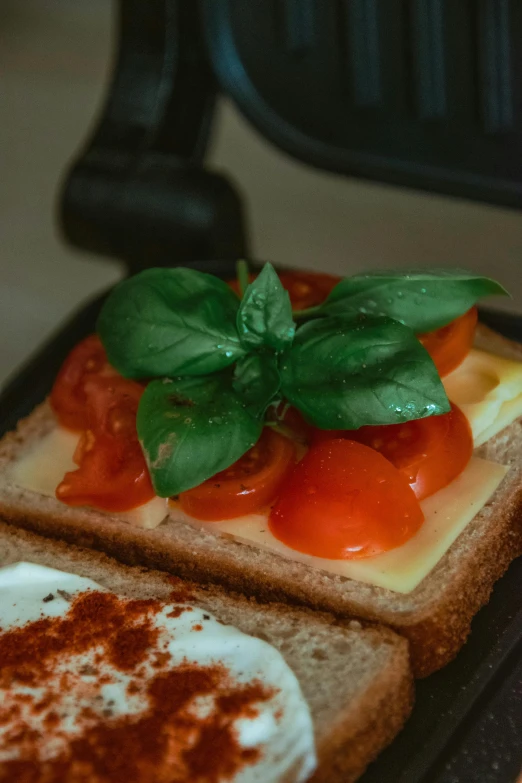 a sandwich with eggs, tomato and cheese on a plate