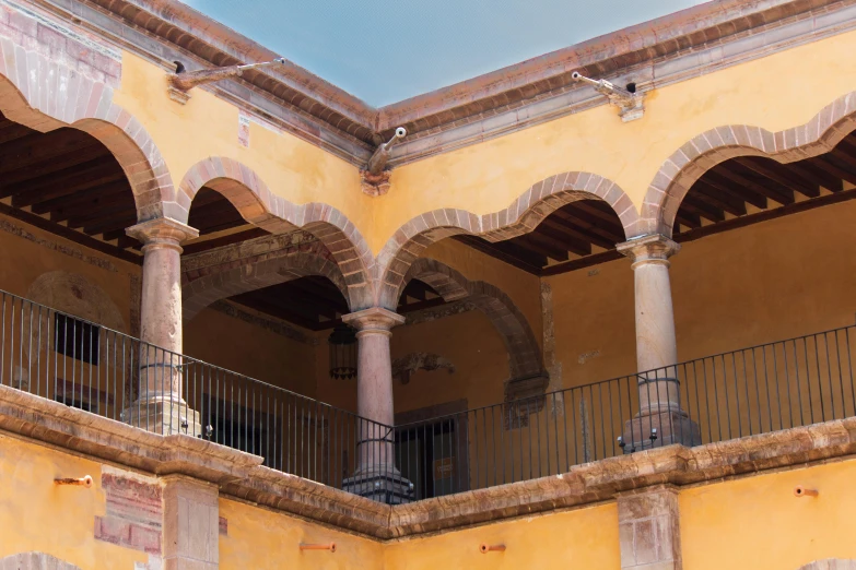 a porch with columns and railing in the middle