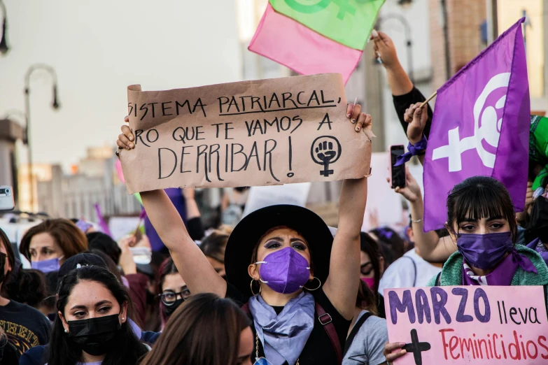 women holding up signs in spanish and english