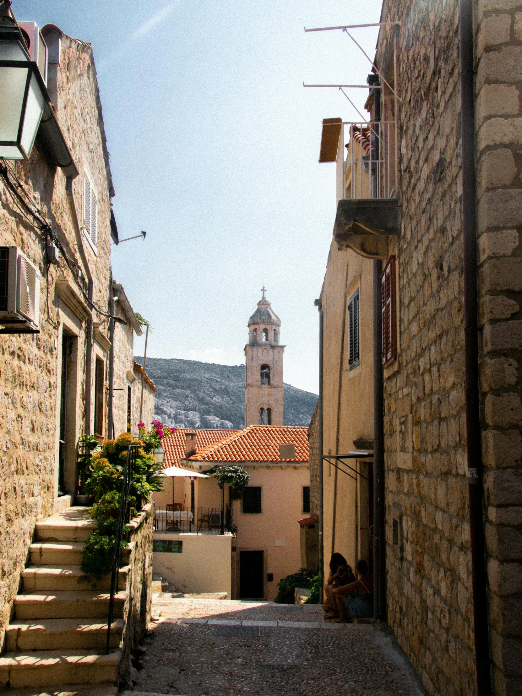 narrow cobblestone street with stairs and buildings