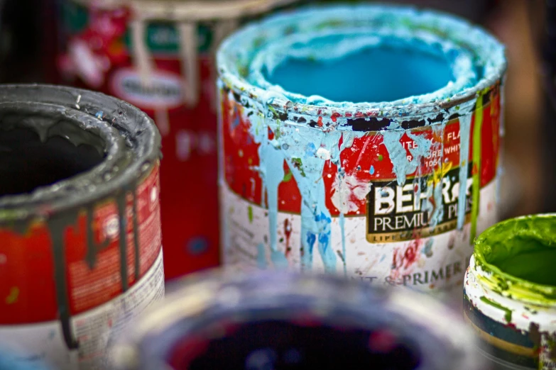 several paint cans with different colors of paint