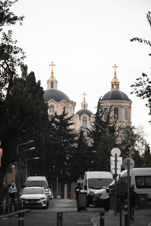 cars are traveling down a quiet street past large cathedrals