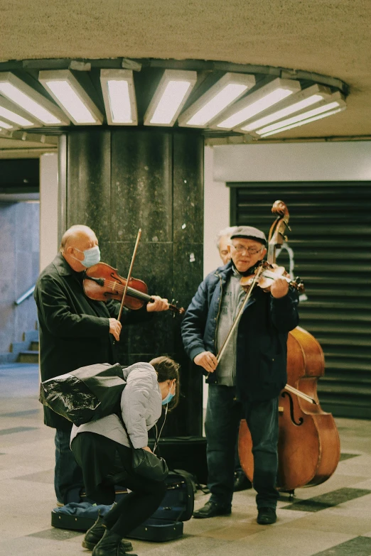 four men are playing instruments in a large room