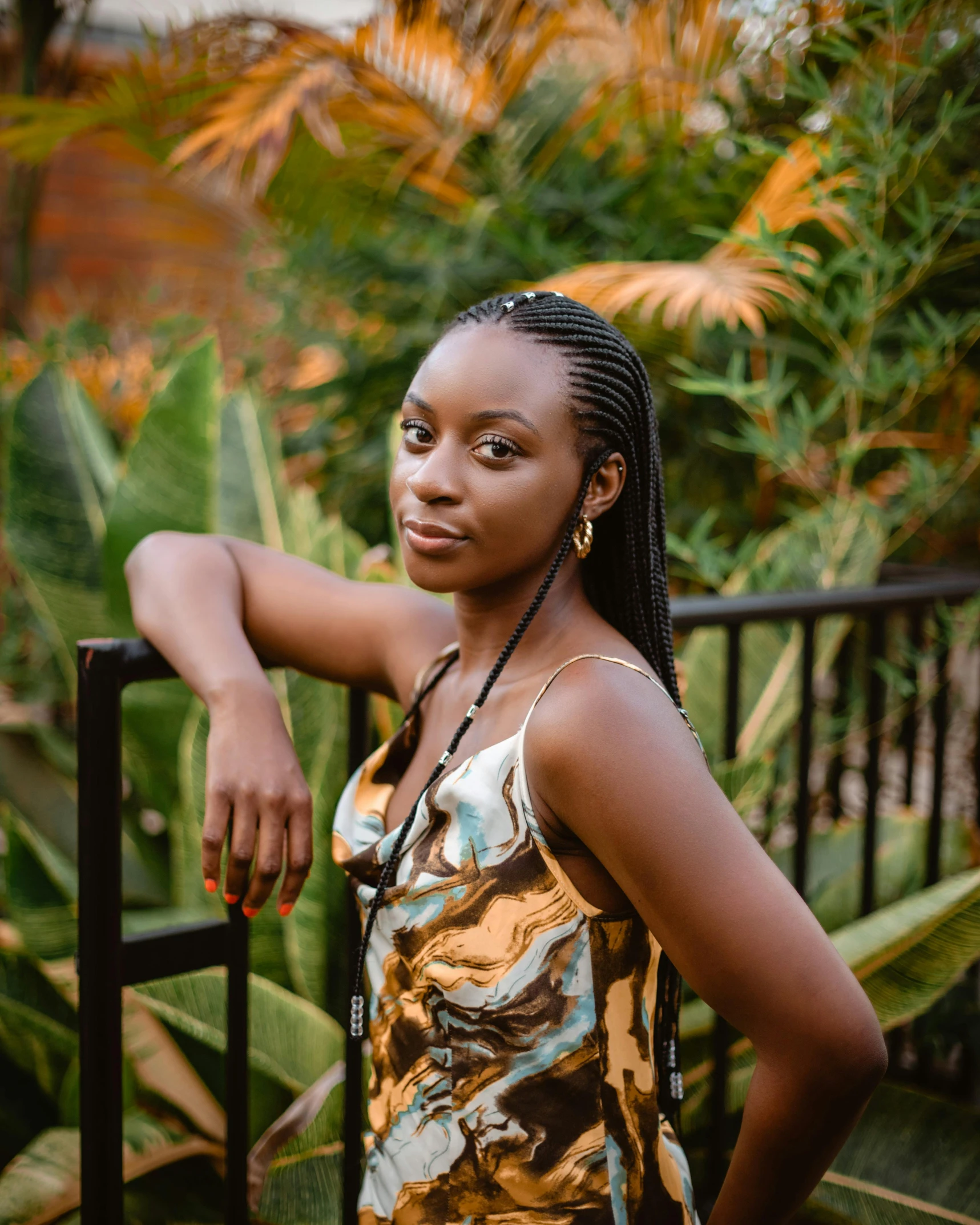 a pretty black woman standing by a fence