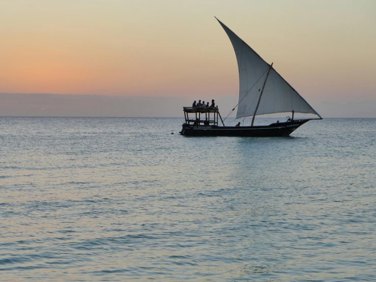 the boat is traveling out to sea with its sails down