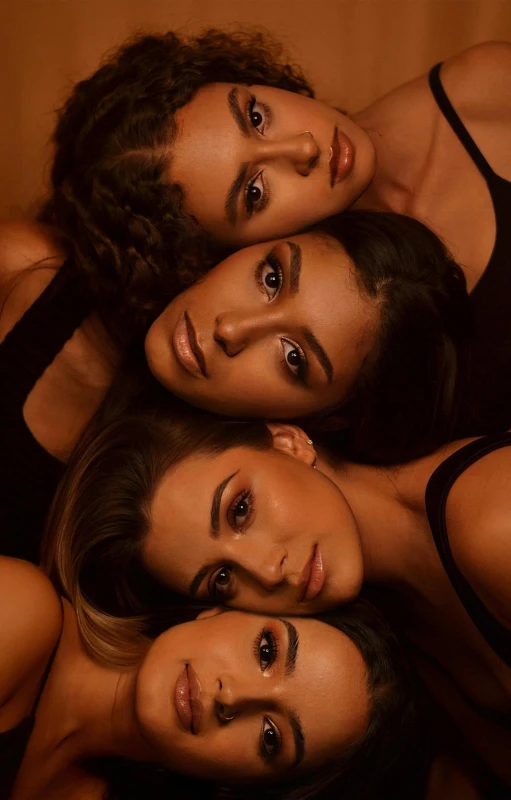 three beautiful women posing for the camera in black dresses